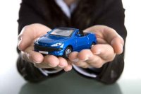 A woman holding a blue car